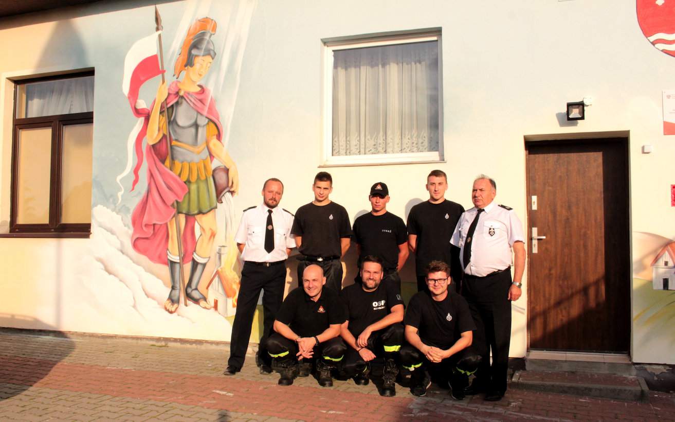 Druhowie reprezentujący jednostkę w Konojadzie pod legendarnym już muralem ze świętym Florianem. Adam Kaczmarek poleca takie przedsięwzięcie wszystkim druhom w kraju
