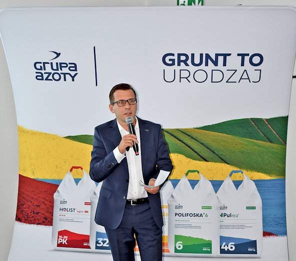 Sławomir Zając, dyrektor Biura Marketingu Segmentu Agro i widoczna na banerze nowa symbolika i kolorystyka opakowań nawozów Grupy Azoty 