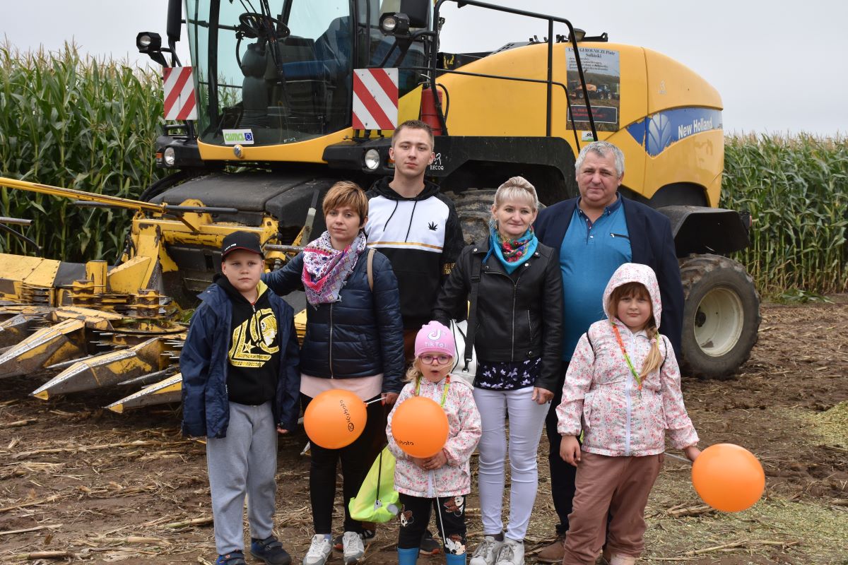 Adrian Soliński, w którego gospodarstwie odbył się Powiatowy Dzień Kukurydzy, jest absolwentem szkoły rolniczej. Wraz ze starszym bratem Mateuszem pomaga rodzicom Marzenie i Andrzejowi w prowadzeniu gospodarstwa w miejscowości Osiek Kolonia w powiecie brodnickim, specjalizującego się w hodowli bydła i produkcji mleka. Gospodarstwo dostarcza mleko do oddziału SM Mlekovita w Lubawie. Stado bydła liczy 170 szt., z czego 90 to krowy mleczne. Produkcja roślinna prowadzona jest na areale 170 ha. Dodatkowa działalność to wykonywanie usług rolniczych, jak cięcie kukurydzy na kiszonkę, wysiew nasion, zbiór i prasowanie trawy. Na zdjęciu od lewej wnuk Wiktor, córka Andżelika, syn Adrian, wnuczka Julia, Marzena i Andrzej Solińscy oraz wnuczka Nicola