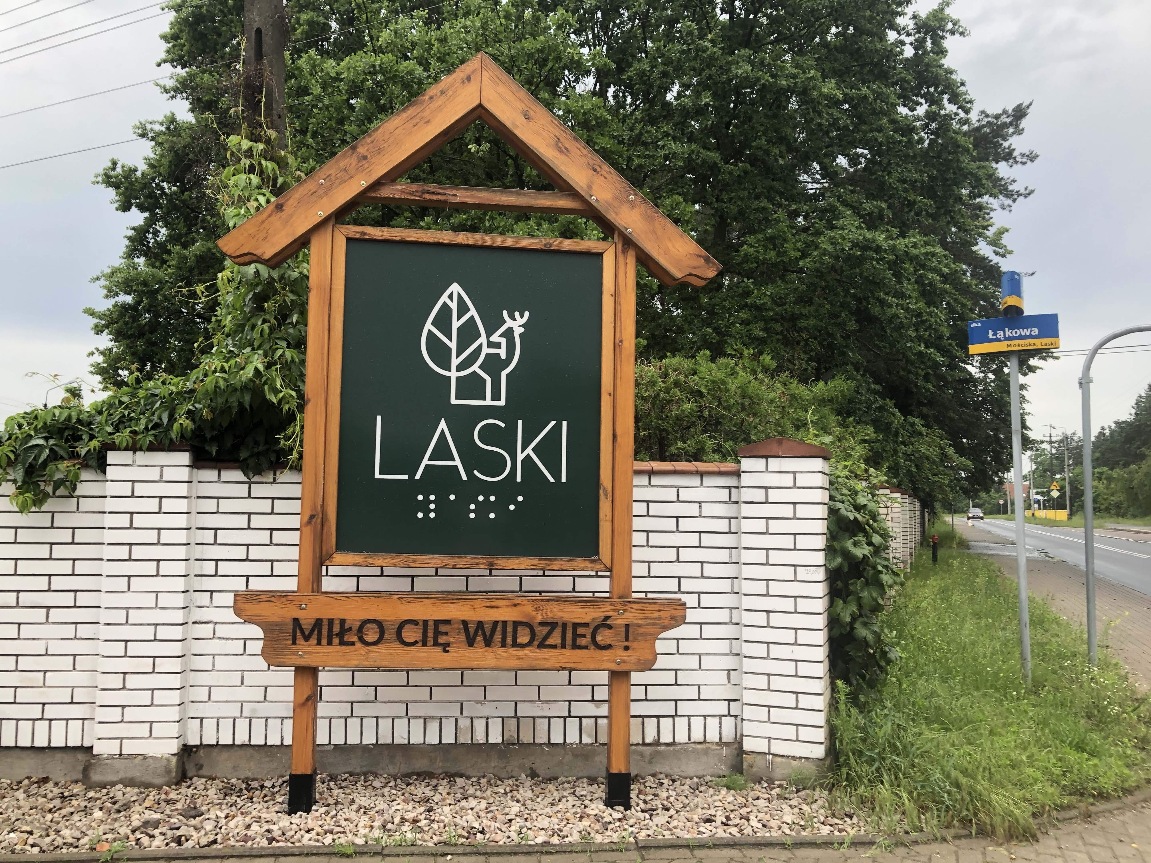 Logo Lasek z łosiem i zapisem Braille’a 