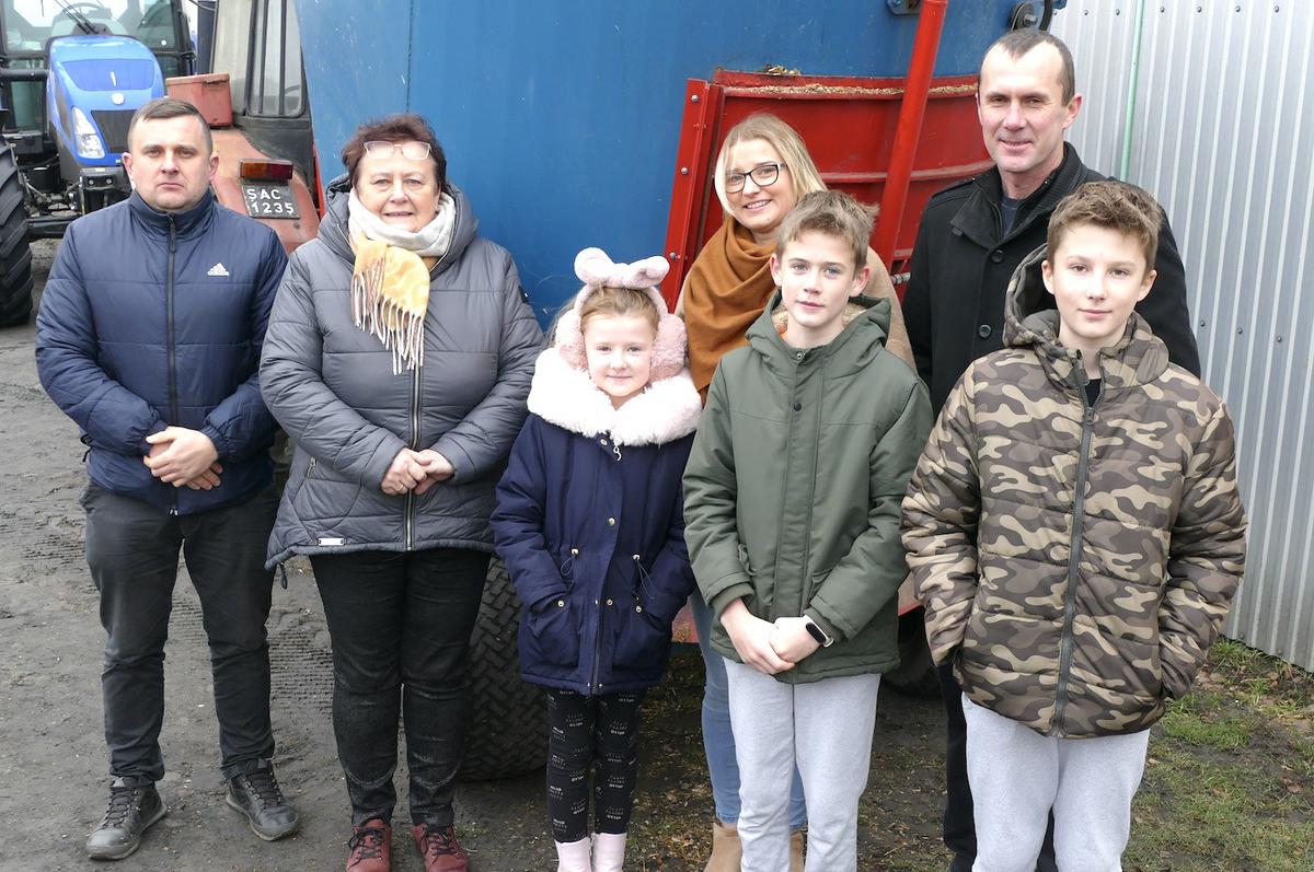 Mariola i Krystian Burdelakowie prowadzą w miejscowości Maszew (w gminie Warta), nieduże, rodzinne gospodarstwo mleczne o powierzchni 24 ha, z których połowa jest dzierżawiona. Uprawa kukurydzy zajmuje 5 ha, podobny areał przeznaczony jest pod uprawę traw (głównie rajgrasu), a pozostałe grunty stanowią zasiewy zbóż. Hodowcy są dostawcami mleka do Okręgowej Spółdzielni Mleczarskiej WART- MILK w Sieradzu, do której sprzedają około 10 tys.litrów mleka miesięcznie.  Na zdjęciu(z prawej): Mariola i Krystian Burdelakowie z synami: Kamilem, Łukaszem i córką Leną oraz (od lewej) z Małgorzatą Jasek – kierownik Działu Skupu sieradzkiej spółdzielni i Łukaszem Ludwiczakiem – instruktorem służby surowcowej