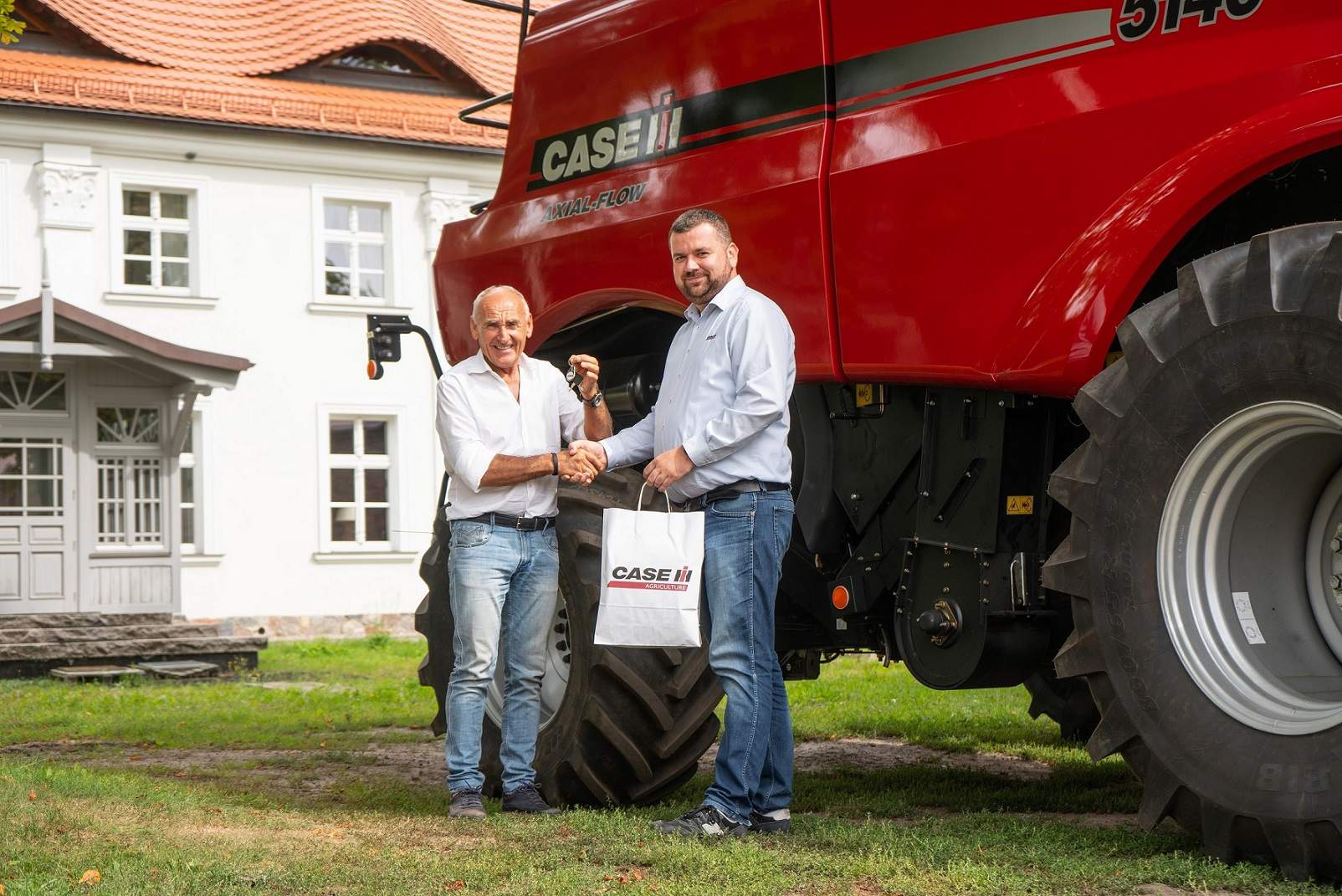 Paweł Kania, specjalista ds. maszyn żniwnych przedstawiciel Case IH wręcza Czesławowi Langowi kluczyki do nowego kombajnu Axial-Flow 5140